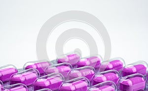 Macro shot of purple caplets pills in blister pack on white background. Mild to moderate pain management. Pain killer medicine.