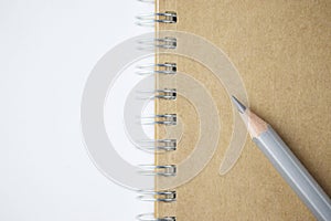 Macro shot of sharpened pencil on brown notebook