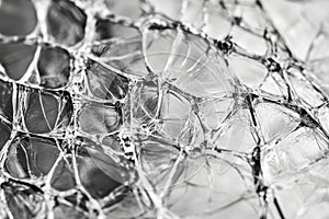 Macro shot of shattered glass texture, intricate web of cracks forming complex geometric patterns.
