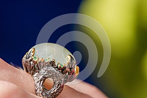 Macro shot of silver engagement ring on colorful, sparkling background.