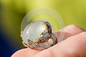 Macro shot of silver engagement ring on colorful, sparkling background.