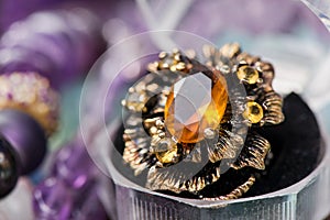 Macro shot of silver engagement ring in gift box on colorful, sparkling background.