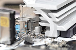 Macro shot of a silver heat sink dissipating heat from the power section on the motherboard of a desktop computer.