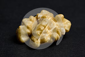 Macro Shot of Single Walnut Kernel on Black Background