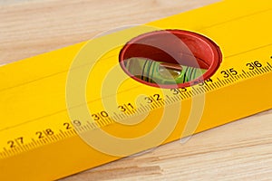 Macro shot of a spirit level with ruler on a wooden background