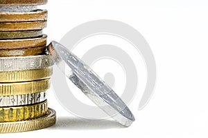 A macro shot of a stack of coins stacked in a bar, isolated on a white background, with space for text on the right and a silver c