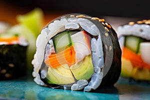 macro shot of a vegetarian sushi roll with carrots, cucumber, avocado, and pickled radish