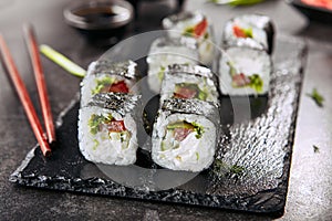 Macro shot of vegetarian sushi rolls with rice, cream cheese, chuka salad, tomato, cucumber and nori. Fresh veggie roll with chops