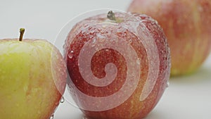 Macro tasty eco natural apples in water drops under drizzle rain, water pouring on heap of organic red appetizing fruits