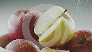 Macro tasty eco natural apples in water drops under rain, water pouring on heap of organic red appetizing fruits