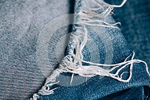 Macro texture of jeans hole and threads.