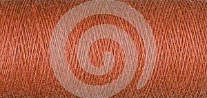 macro texture of a skein of orange sewing thread