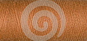 macro texture of a skein of orange sewing thread