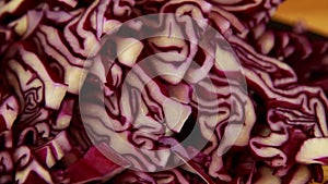 Macro Tracking shot of Sliced red cabbage on chopping  board with knife left to right.