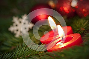 Macro of two Burning Candles with Christmas Background