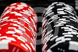 A macro of two rows of betting chips. one red and one black row with the side spots in random patterns.  Medium macro depth of