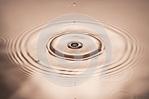 Macro view of falling drops on water surface isolated on pink background