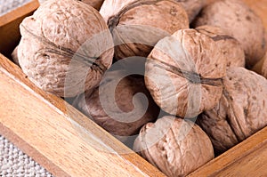 Macro view of a group of walnuts in a brown wooden box