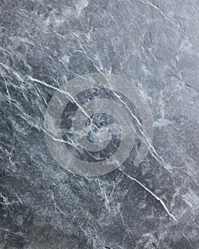 Leathered soapstone surface in natural gray with white marble-like veining in macro flatlay photo