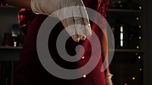 Macro view of man hand in glove adding salt in process of preparing meal in a slowmo