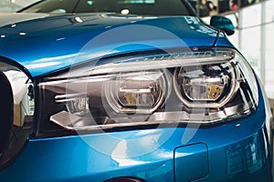 Macro view of modern blue car xenon lamp headlight.