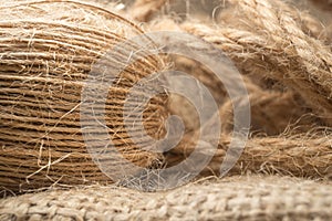 Macro view with natural jute twine roll isolated on natural linen fabric