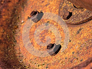 Macro view of a rusty nut on a grungy old bolt on a weathered machinery metal sheet