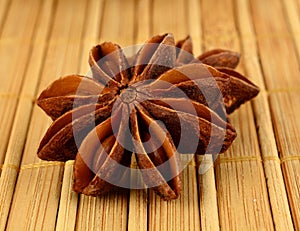 Macro view of two anises on wooden mat