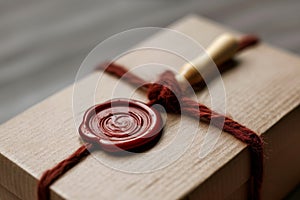 macro view of a wax seal stamp on the lid of a small cardboard gift box