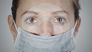 Macro view of woman`s face in medical protective mask.