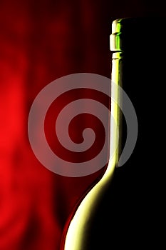 Macro of a wine bottle against a red background