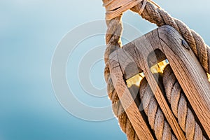 Macro of wooden pulley wit nautical ropes of traditional sailboat