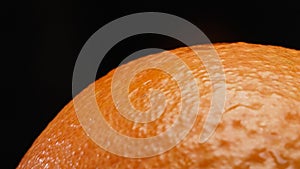 Macrography of a fresh orange against a striking black background. Comestible. photo
