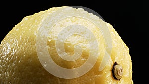Macrography of a lemon against a bold black background. Close up. Comestible.