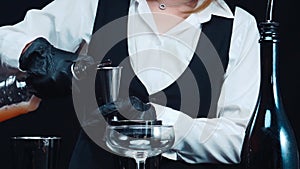 Macrography of the skillful hands of a bartender mix a cocktail. Comestible.