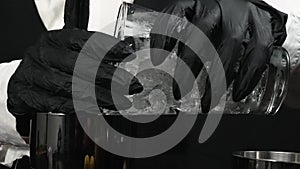 Macrography of the skillful hands of a bartender mix a cocktail. Comestible.