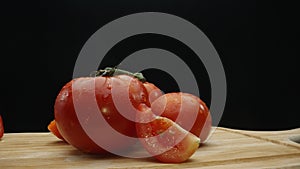 Macrography, slices of tomato placed on board with black background. Comestible. photo
