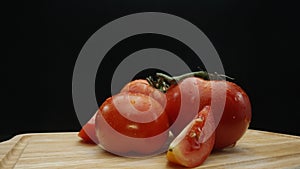 Macrography, slices of tomato placed on board with black background. Comestible. photo