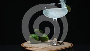 Macrography of margarita is captured in a glass with lime slice. Comestible.