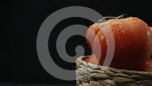 Macrography, tomatoes nestled within basket with black background. Comestible.