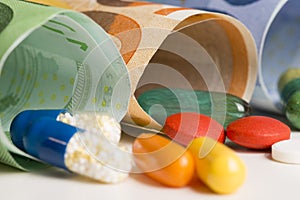 Macrophotography with colourful pharmaceutical drugs on rolled up euro banknotes