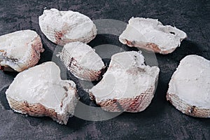 Macrourus fish frozen, fresh, sliced and cut in portions. Gray background