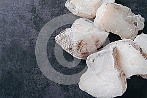 Macrourus fish frozen, fresh, sliced and cut in portions. Gray background. copy space