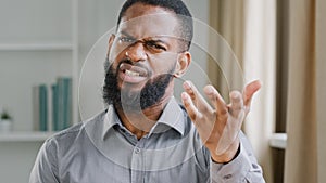 Mad angry bearded African American businessman talking to camera aggressive worker office manager entrepreneur ethnic