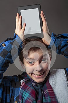 Mad boy holding a tablet computer on his head