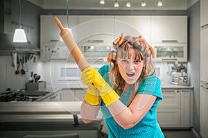 Mad and crazy housewife woman with kitchen roller