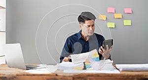 Mad crazy man employee sitting in office workplace with sticky notes all around, shouting furious angry, pissed off