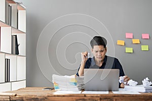 Mad crazy man employee sitting in office workplace with sticky notes all around, shouting furious angry, pissed off