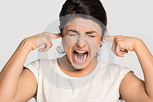 Mad ethnic girl scream bothered by disturbing sound