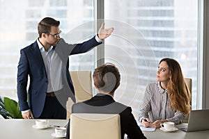 Mad male worker asking female partner leave meeting